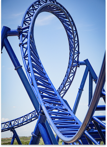 Get ready for a thrilling ride! This image captures the breathtaking view of roller coaster tracks curving and looping in a mesmerizing blue structure. Feel the adrenaline rush!